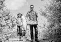 Father and daughter with shovel and watering can in garden. It is time to plant prepare beds and care for lawn. Pick out