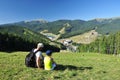 Father and daughter sit on the grass and admire the mountain scenery Royalty Free Stock Photo