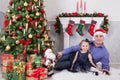 Father and daughter sit near the Christmas tree. Father have a S Royalty Free Stock Photo