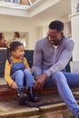 Father And Daughter Sit On Step At Home Putting On Boots Before Going On Family Walk Royalty Free Stock Photo