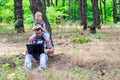 Father and daughter are sitting in the park with a laptop, a bright summer photo with free space Royalty Free Stock Photo