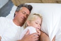 Father and daughter sleeping together on bed in bedroom Royalty Free Stock Photo