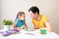 Father and daughter smile and draw a rainbow together. The father and the child and have fun drawing Royalty Free Stock Photo