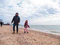 Father and daughter smiling walking running on empty beach. Lifestyle photo real people. Happy active family having fun Royalty Free Stock Photo