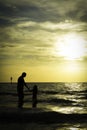 Father and Daughter Sunset Silhouettes by the Sea