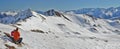 Father and daughter taking a rest sitting in front of fascinating snowy Pyrenees mountain panorama