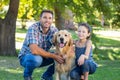 Father and daughter with their pet dog in the park