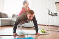 Father and daughter are training at home. Workout in the apartment. Sports in home conditions. They make the doing plank