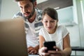 Father and daughter using laptop and mobile phone in the living room Royalty Free Stock Photo