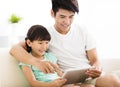 father and daughter using tablet on sofa Royalty Free Stock Photo