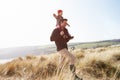 Father And Daughter Walking Through Dunes On Winter Beach Royalty Free Stock Photo