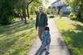 Father with daughter walking in park at sunny day. little girl leading dad along the way. Family authentic lifestyle