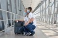 Father and daughter wearing medical masks with luggage, passports, tickets at the airport, traveling during the coronavirus