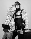 Father and daughter in workshop. Repairman in uniform. Engineer. Bearded man with little girl. construction worker