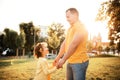 Father and daughter in yellow clothes walk hold hands. Family, hapiness, man and child together