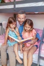 Father and daughters girls at home reading book