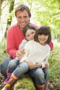 Father and daughters outdoors in woods sitting Royalty Free Stock Photo