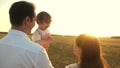 Father with daughters resting in the park. concept of happy family and childhood. The family plays with the baby at