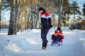 Father drag his boy in sled