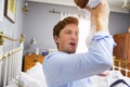 Father Dressed For Work Changing Baby's Diaper In Bedroom Royalty Free Stock Photo