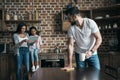 Father drinking coffee and cleaning table while mother and daughter using digital tablet Royalty Free Stock Photo