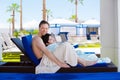 Father drying off on blue lounger with disabled son off side of Royalty Free Stock Photo