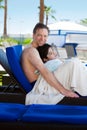 Father drying off on blue lounger with disabled son off side of Royalty Free Stock Photo