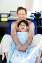 Father drying off on blue lounger with disabled son off side of Royalty Free Stock Photo