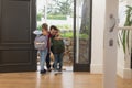 Father embracing his children at door in a comfortable home