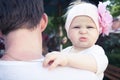 Father embracing his cute funny little baby. Father is looking away, baby with funny face is looking on camera and embracing his f Royalty Free Stock Photo