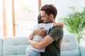 Father embracing son while sitting on sofa