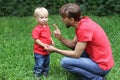 Father emotionally talks with a frustrated child. Upset toddler and his dad. Parenting difficulties concept. Family look clothing. Royalty Free Stock Photo