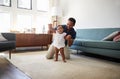 Father Encouraging Baby Daughter To Take First Steps At Home Royalty Free Stock Photo