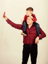 Father example of noble human. Father little son red shirts family look outfit. Taking selfie with son. Child riding on