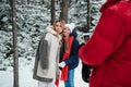 The father of the family takes photos of his wife and daughter on a smartphone, they make faces, everyone has fun