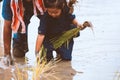 Father farmer teaching his child planting rice in the rice field