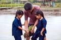 Father farmer teaching his children planting rice