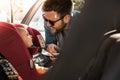 Father fasten his baby in car seat Royalty Free Stock Photo