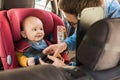 Father fasten his baby in car seat Royalty Free Stock Photo