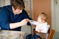 Father feeding baby girl from spoon mashed vegetables and puree. food, child, feeding and people concept -cute toddler Royalty Free Stock Photo