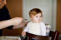 Father feeding baby girl from spoon mashed vegetables and puree. food, child, feeding and people concept -cute toddler Royalty Free Stock Photo