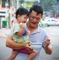 Father feeding daughter on the street of Ho Chi Minh, Vietnam. Royalty Free Stock Photo