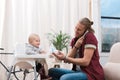 father feeding his little son with baby food while talking Royalty Free Stock Photo