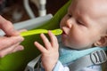 Father feeding little baby boy with first solid food. Giving a spoon with baby puree Royalty Free Stock Photo
