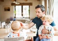 Father feeding two toddlers at home.