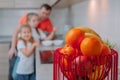A father feeds his daughters in the kitchen on a background of fruits