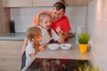 A father feeds his daughters in the kitchen on a background of fruits