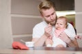 Father feeds his naughty little child who refuses to eat fruit puree Royalty Free Stock Photo