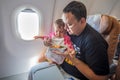 Father feeds the little toddler on the plane with special meals