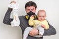 Father with gas mask is holding dirty diaper and little baby Royalty Free Stock Photo